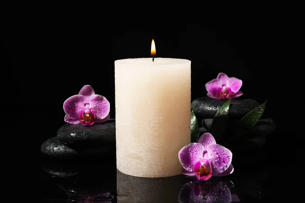 Composition with candle and spa stones on black background — Stock Photo, Image