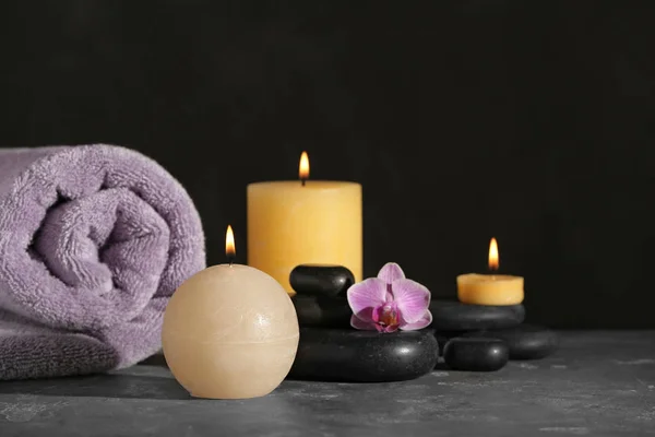 Composição com velas e pedras de spa em mesa cinza — Fotografia de Stock