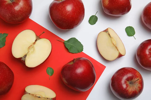 Flache Komposition mit reifen saftigen roten Äpfeln und Blättern auf farbigem Hintergrund — Stockfoto