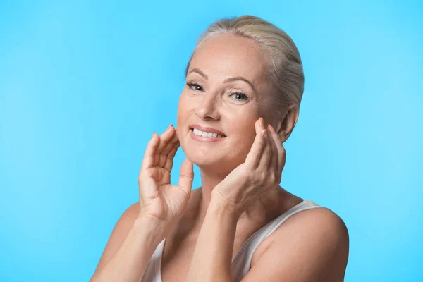 Portrait of beautiful matre woman with perfect skin on light blue background — Stok Foto