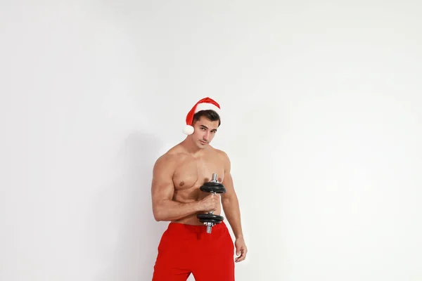 Sexy Santa Claus sin camisa con mancuerna sobre fondo claro —  Fotos de Stock