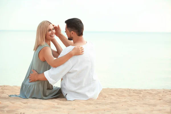 Happy Romantic par sitter på stranden, utrymme för text — Stockfoto