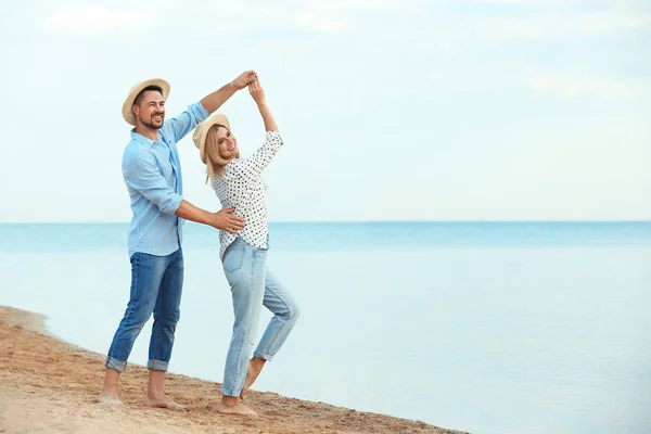 Счастливая романтическая пара танцует на пляже, пространство для текста — стоковое фото