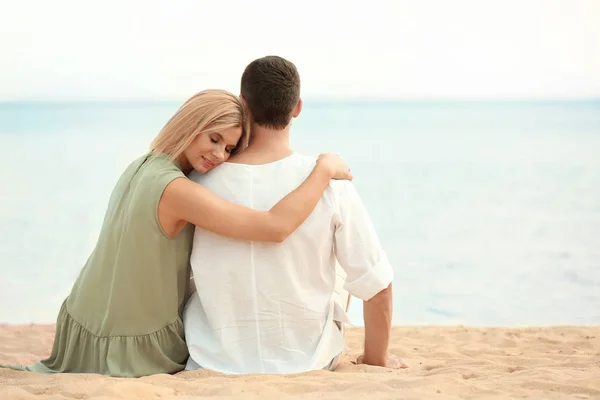 Lycklig romantiskt par sitter tillsammans på stranden, utrymme för text — Stockfoto