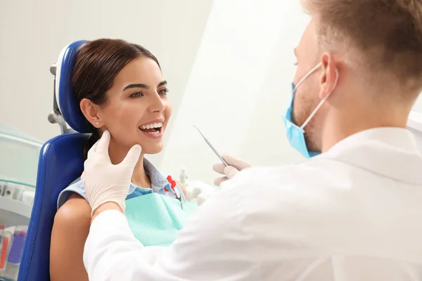 Professionel tandlæge arbejder med patienten på klinikken - Stock-foto