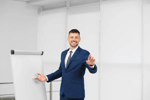 Professioneller Businesstrainer in der Nähe von Flipchart-Tafeln in Innenräumen. Raum für Text — Stockfoto