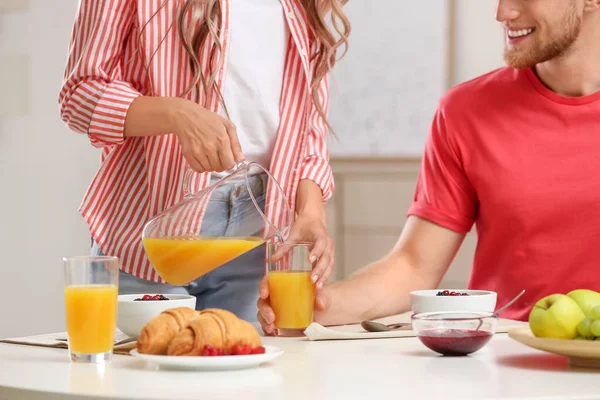 Feliz pareja joven desayunando en la mesa en la habitación — Foto de Stock