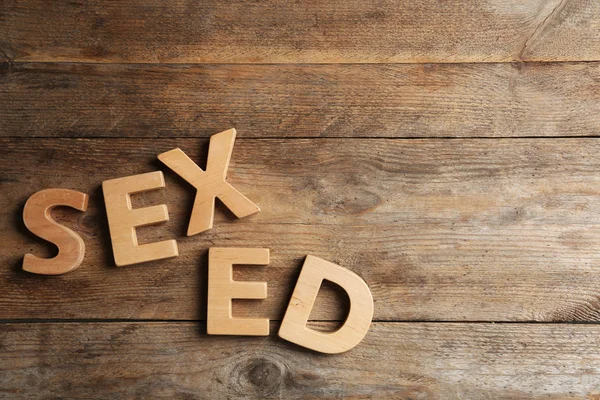 Wyrażenie "Sex Ed" wykonane z różnych liter na drewnianym tle, płaski lay — Zdjęcie stockowe