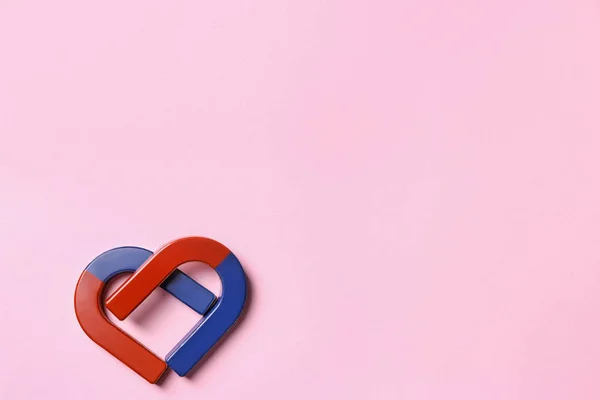 Red and blue horseshoe magnets on pink background, flat lay. Space for text — Stock Photo, Image