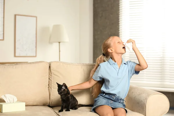 Menina com gato sofrendo de alergia em casa — Fotografia de Stock