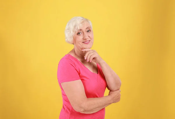 Donna anziana in abito casual su sfondo giallo — Foto Stock