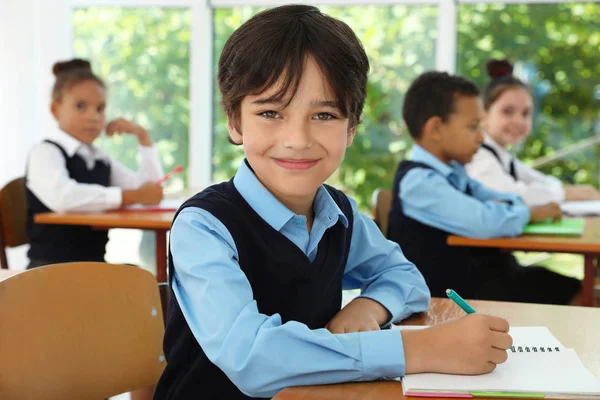 Jongen het dragen van nieuwe school uniform in het klaslokaal — Stockfoto