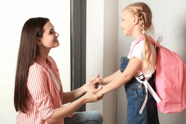 Mãe feliz e criança pequena com saco escolar na porta — Fotografia de Stock