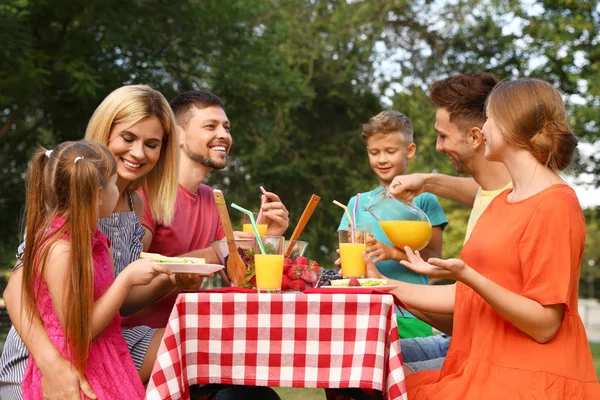 Familii fericite cu copii care au picnic la masă în parc — Fotografie, imagine de stoc