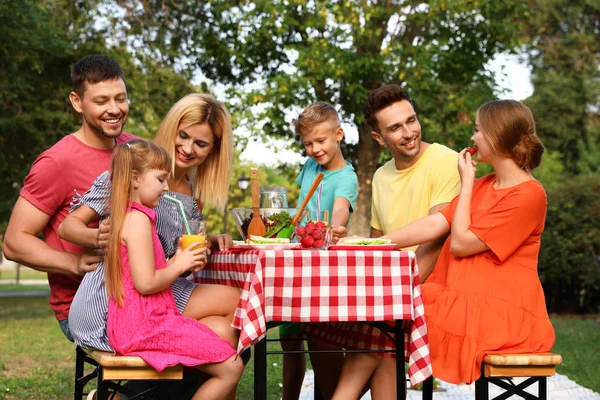 Familii fericite cu copii care au picnic la masă în parc — Fotografie, imagine de stoc