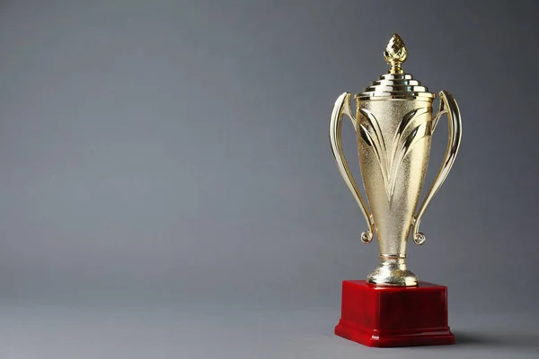 Golden trophy cup on grey background. Space for text — Stock Photo, Image