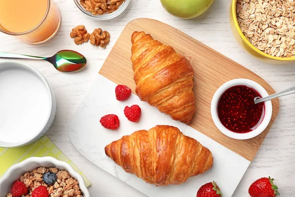 Smaklig frukost med croissanter serveras på vitt träbord, platt ligg — Stockfoto