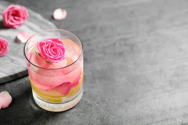 Un vaso de bebida refrescante con limón y rosas sobre una mesa gris. Espacio para texto —  Fotos de Stock