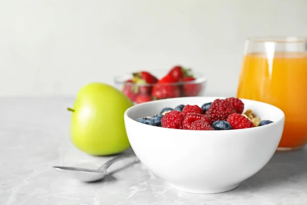Zdrowe śniadanie z granolą i jagodami na jasnoszarym marmurowym stole — Zdjęcie stockowe