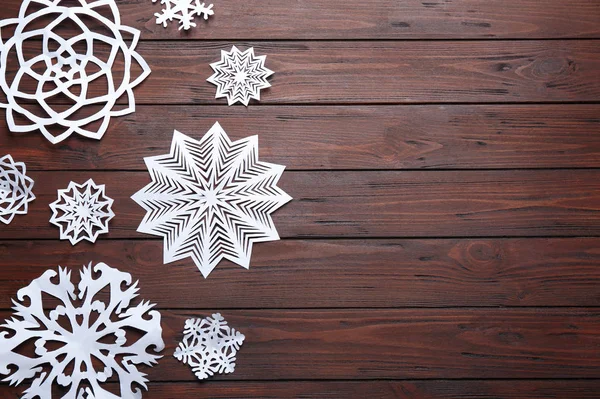 Composição de leigos planos com flocos de neve de papel em fundo de madeira, espaço para texto. Temporada de Inverno — Fotografia de Stock