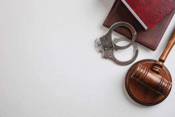 Плоская композиция с наручниками и молотком на белом фоне, место для текста. Уголовное право — стоковое фото