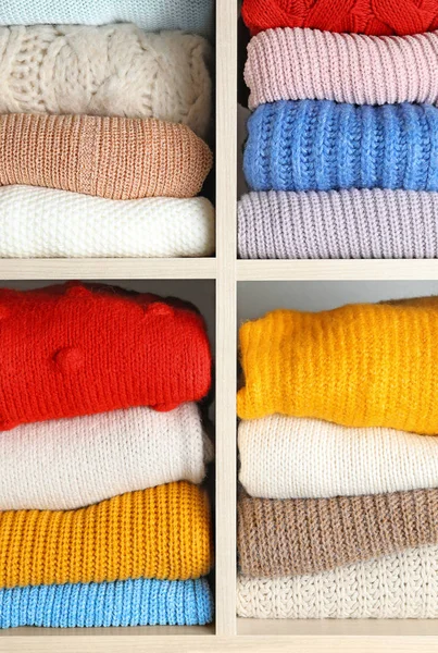 Arkaplan olarak katlanmış renkli kış kazakları raflarda