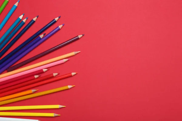 Lápis coloridos sobre fundo vermelho, flat lay. Espaço para texto — Fotografia de Stock