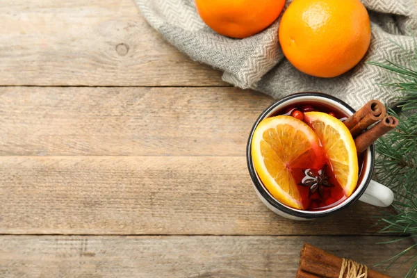 Taza con vino caliente aromático y naranjas sobre mesa de madera, puesta plana. Espacio para texto — Foto de Stock