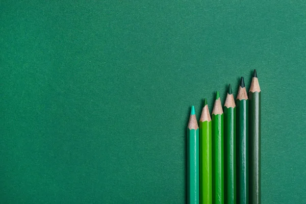 Lápis de cor sobre fundo verde, flat lay. Espaço para texto — Fotografia de Stock