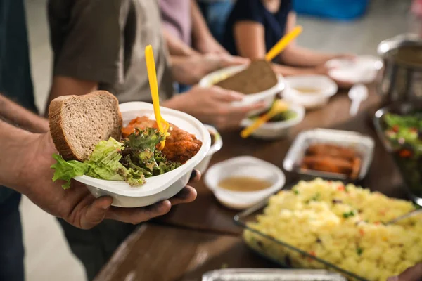 Pobre hombre sosteniendo plato con comida en el centro de caridad, primer plano — Foto de Stock