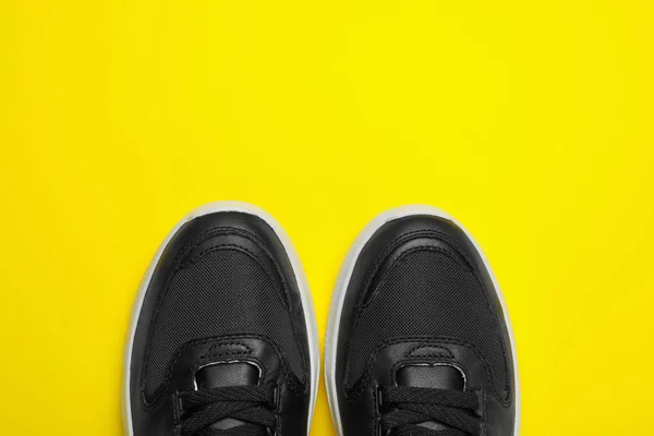 Para stylowych butów na żółtym tle, widok z góry. Miejsce na tekst — Zdjęcie stockowe