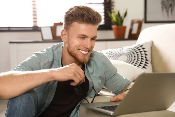 Young man using laptop in living room — Stock Photo, Image