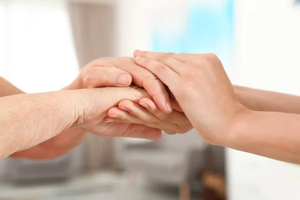 People holding hands together on blurred background, closeup. Help and elderly care concept — Stock Photo, Image