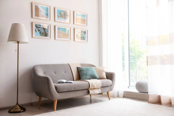 Стильный интерьер комнаты с модной мебелью и картинами на стене — стоковое фото