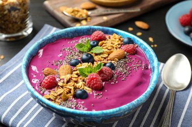 Granola ve tatlı kasesinde meyveli acai smoothie.