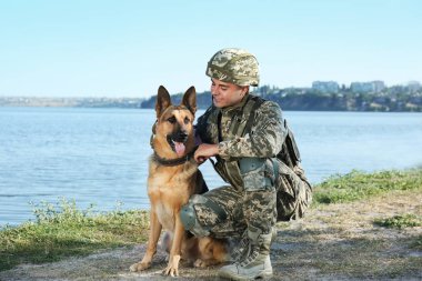 Alman çoban köpeği Nehri yakınında ile askeri üniformalı erkeklere