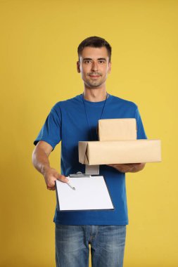 Sarı arka plan üzerinde parsel ve pano ile Mutlu genç kurye