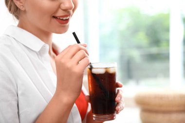 Evde bir bardak kola olan genç kadın, yakın çekim. Ferahlatıcı içecek