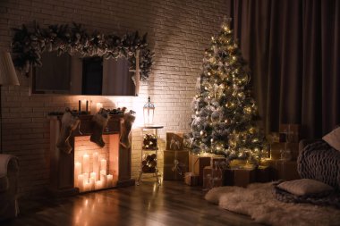 Stylish interior with beautiful Christmas tree and artificial fireplace at night clipart