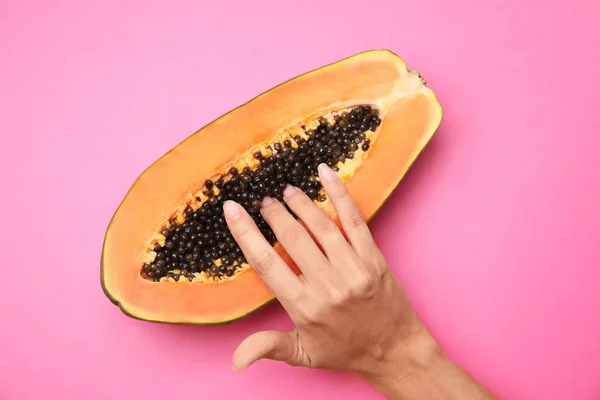 Mujer joven tocando la mitad de la papaya sobre fondo rosa, vista superior. Concepto de sexo — Foto de Stock