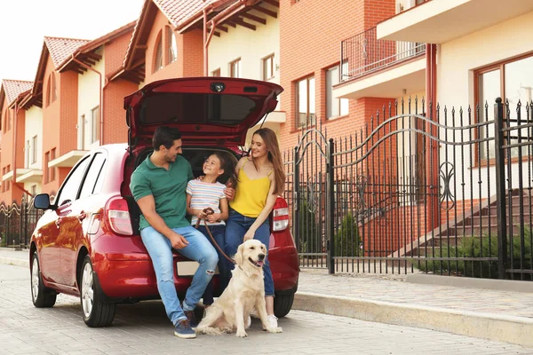 Familia feliz con perro cerca de coche en la calle — Foto de Stock