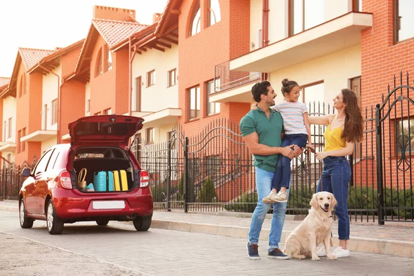 Glückliche Familie mit Hund neben Auto auf Straße — Stockfoto