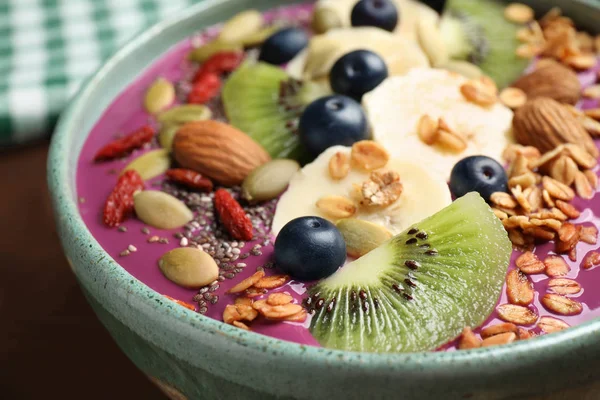 Köstlicher Acai-Smoothie mit Müsli und Früchten in Schüssel auf dem Tisch, Nahaufnahme — Stockfoto