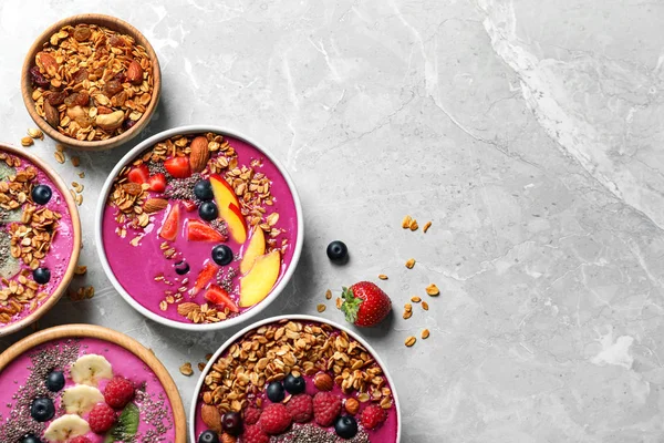 Acai smoothie kaseleri granola ve mermer masa üzerinde böğürtlen, düz yatıyordu. Metin için boşluk
