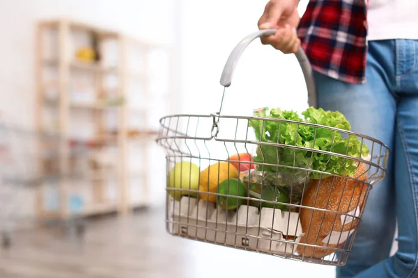 Homme avec panier plein de produits dans l'épicerie, gros plan — Photo