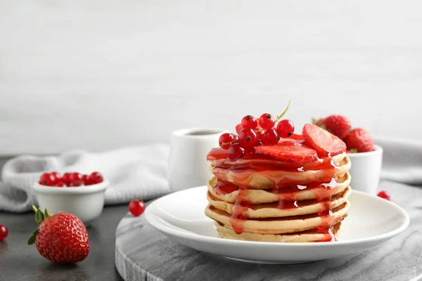 Leckere Pfannkuchen mit frischen Beeren und Sirup auf grauem Tisch — Stockfoto