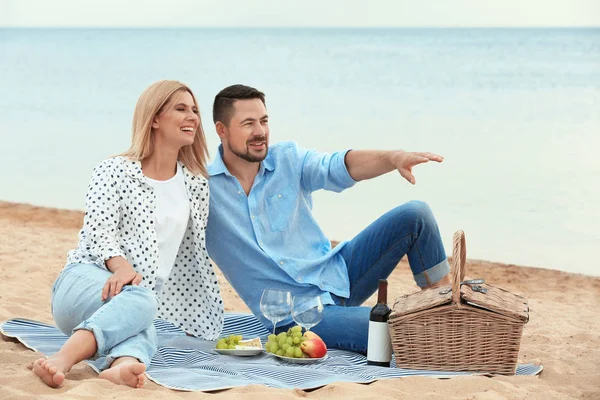 Gelukkig romantisch paar met picknick op het strand — Stockfoto