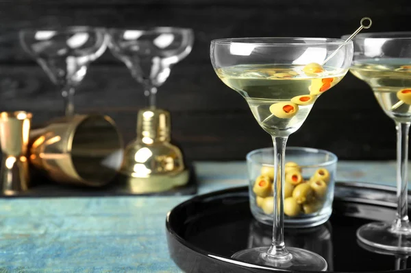 Bir bardak sek Martini, zeytinli, ahşap masa.
