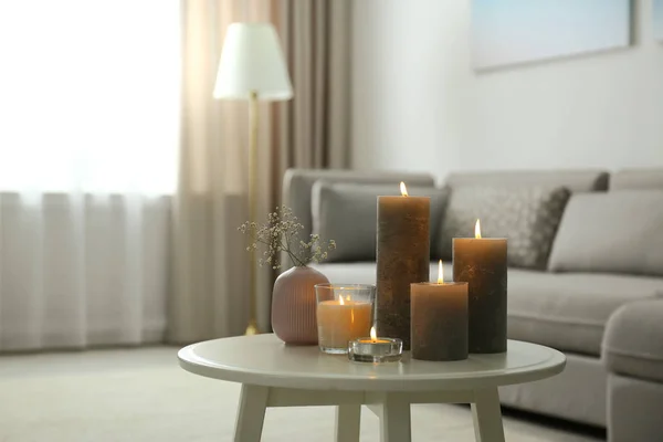 Brinnande dekorativa ljus på bordet i rummet — Stockfoto