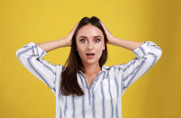 Emotionale junge Frau im lässigen Outfit auf gelbem Hintergrund — Stockfoto